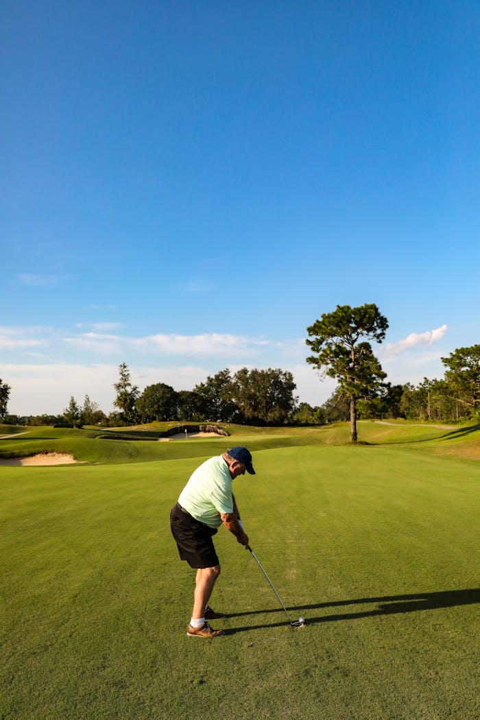 A man golfing under a clear blue sky at a golf course in Eustis, Florida.